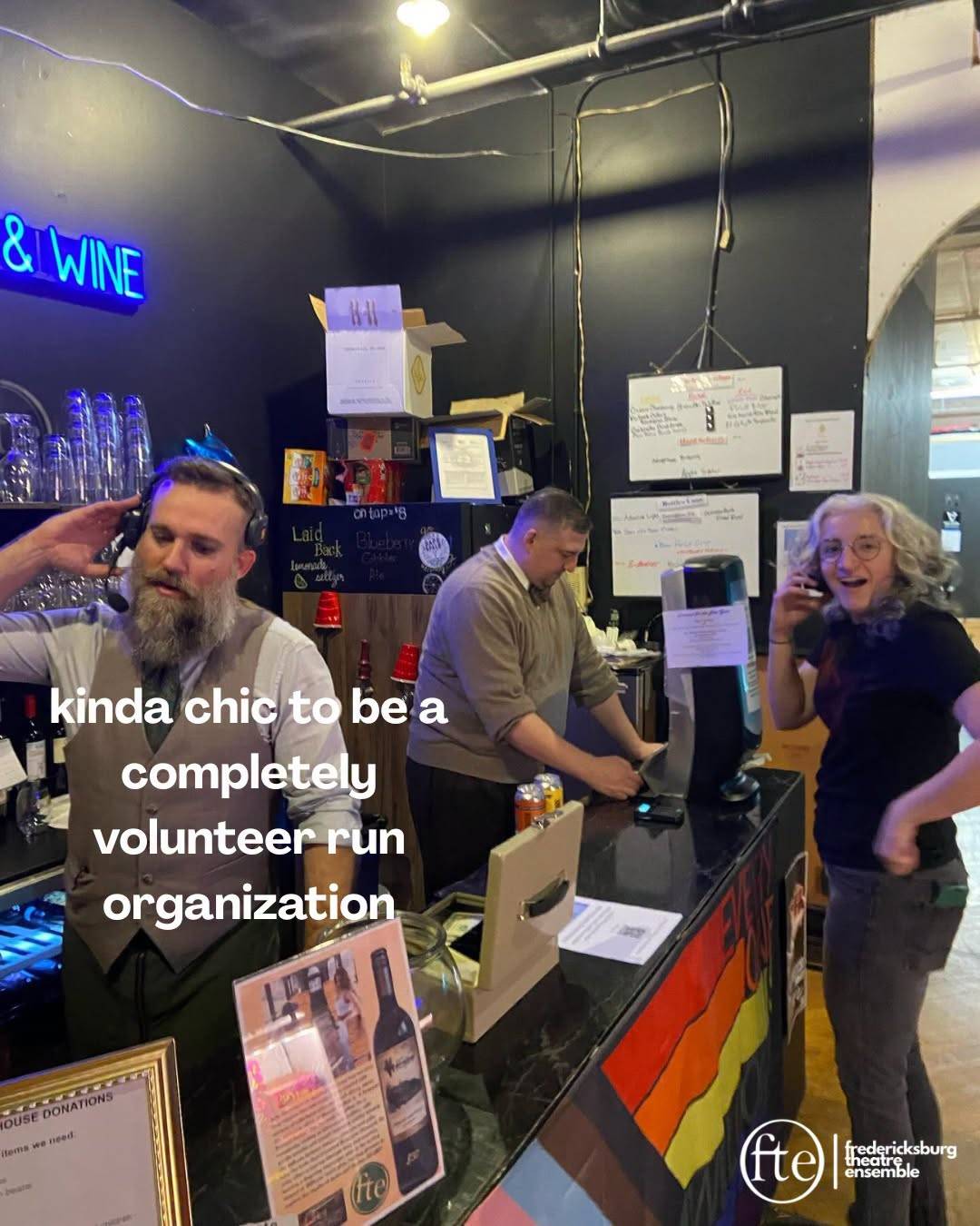 Volunteers working the Fredericksburg Theatre Ensemble bar under a neon “& Wine” sign, over the words “kinda chic to be a completely volunteer run organization”.