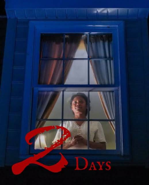 A performer in a white blouse stands behind a lit window of a blue house at night, hands clasped, looking up. Red lettering reads “2 Days”, with a large brushed “2” and “Days” in smaller capitals.
